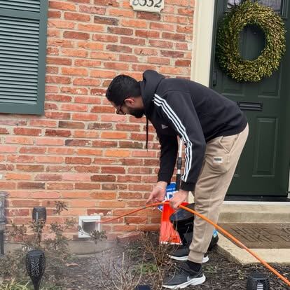 dryer vent cleaning guide: an AirDuctVet technician servicing an exterior vent at a home