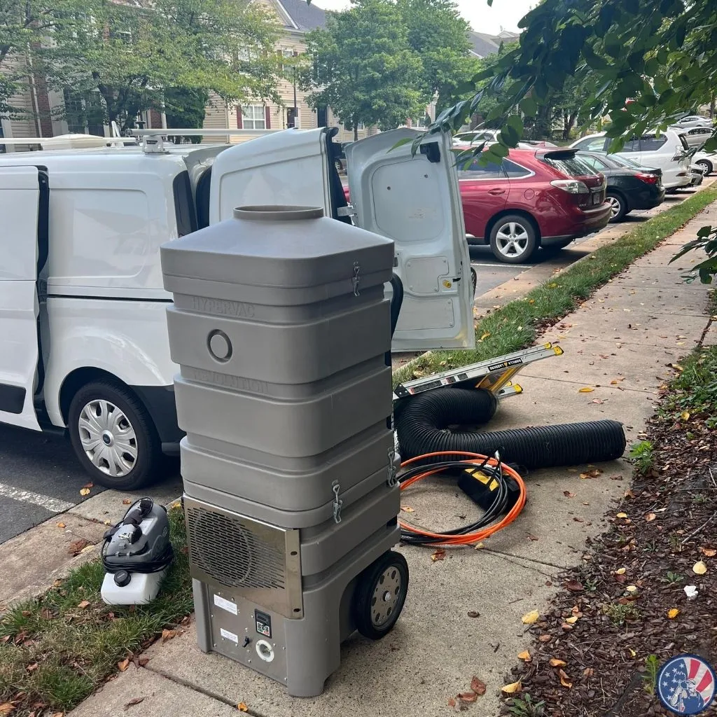 HyperVac Hybrid duct cleaning machine positioned outside a work van during a residential HVAC service