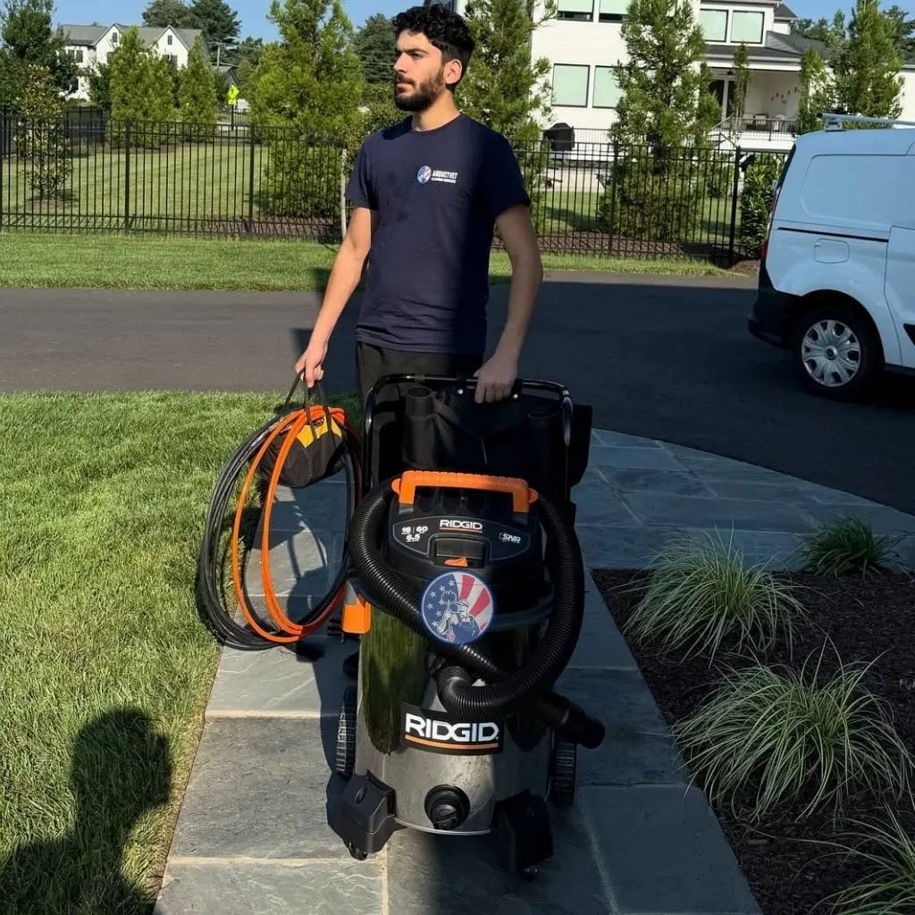 Technician with equipment ready to address warning signs of duct cleaning in Alexandria.