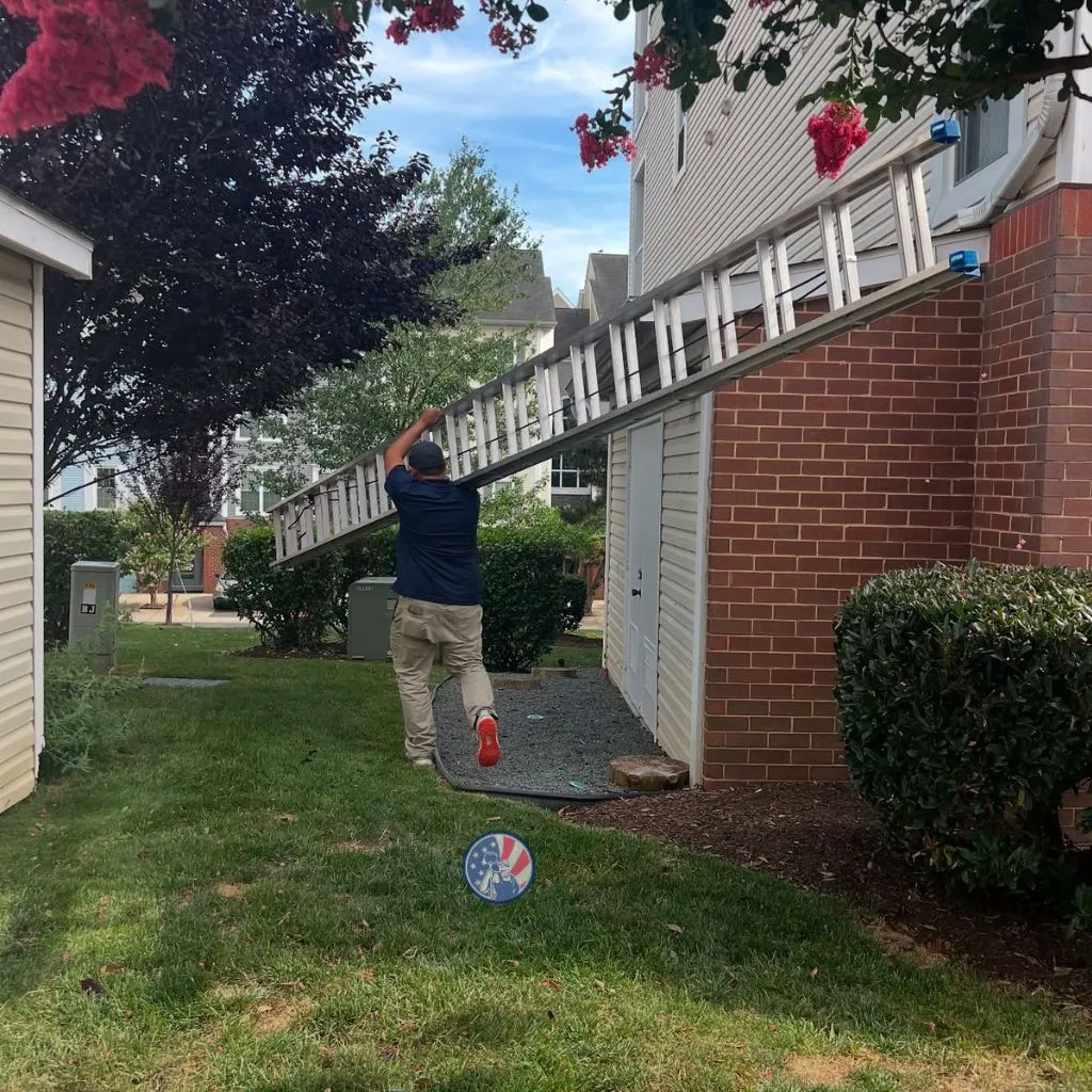 Technician carrying ladder for trusted duct cleaning in Alexandria VA residential home