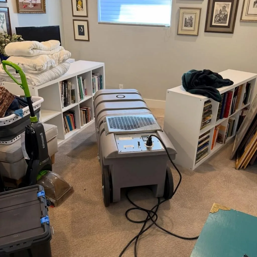 Heavy-duty negative air machine operating in a bedroom to provide clean air for pet owners in Alexandria, shown next to a standard household vacuum.