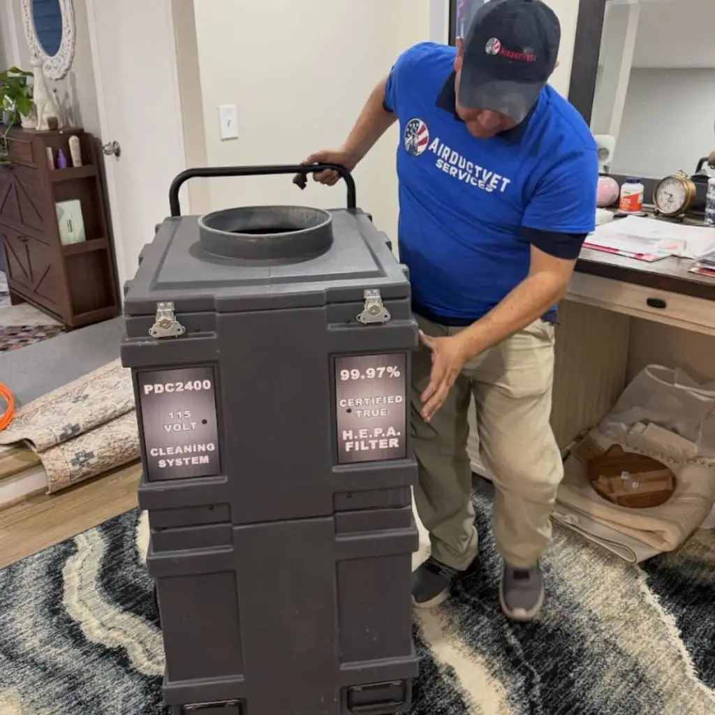 Technician deploying a 99.97% certified HEPA filtration machine, the gold standard for air duct cleaning for pet owners in Alexandria.
