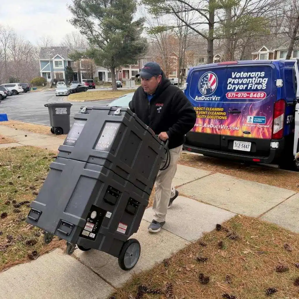 Technician wheeling a HEPA filtration unit from a veteran-owned service van to resolve health risks associated with seniors and dirty air ducts.