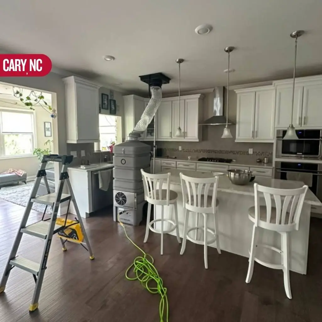Duct cleaning equipment and hose set up in a Cary NC kitchen ceiling vent during an air duct cleaning Cary NC service call